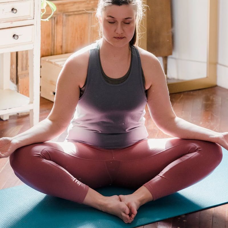 A person in a calm, focused pose in a bright, open space.
